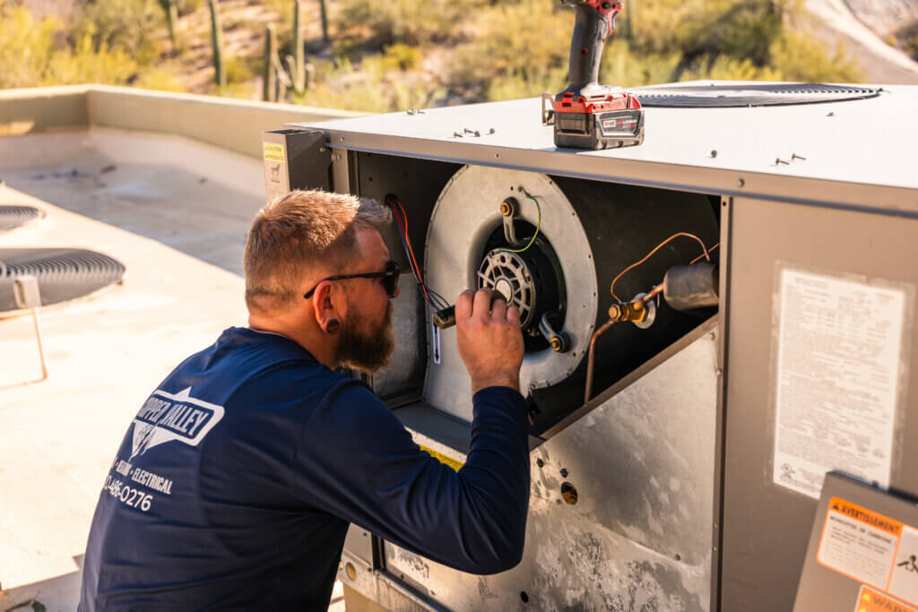 HVAC professional repairing an air conditioning system in Tucson to improve cooling performance and energy efficiency.