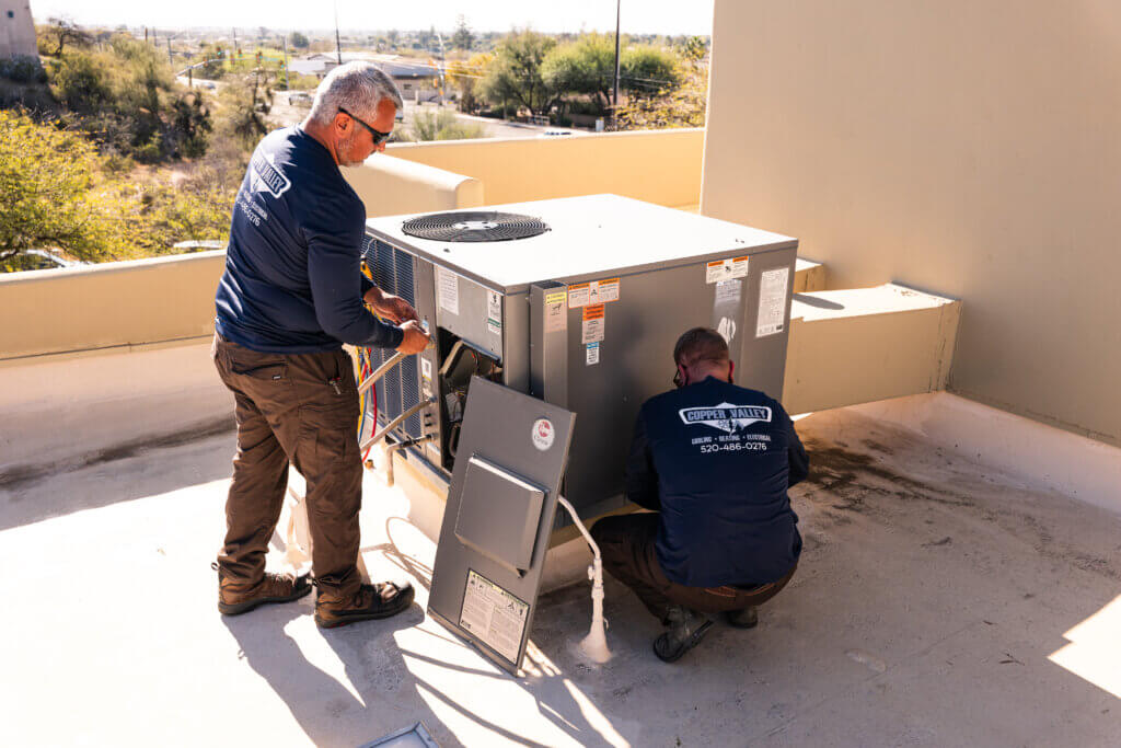Tucson A/C repair specialists servicing a commercial rooftop HVAC system during a maintenance and repair visit.