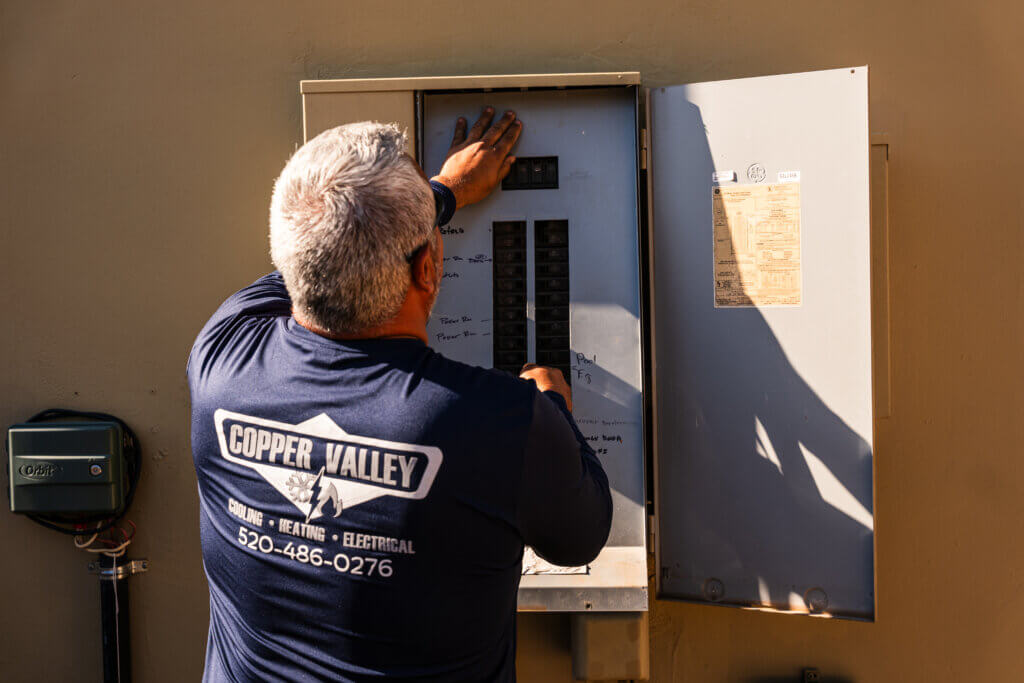 Technician performing electrical panel services while inspecting and servicing a residential electrical panel to ensure safe and reliable operation.