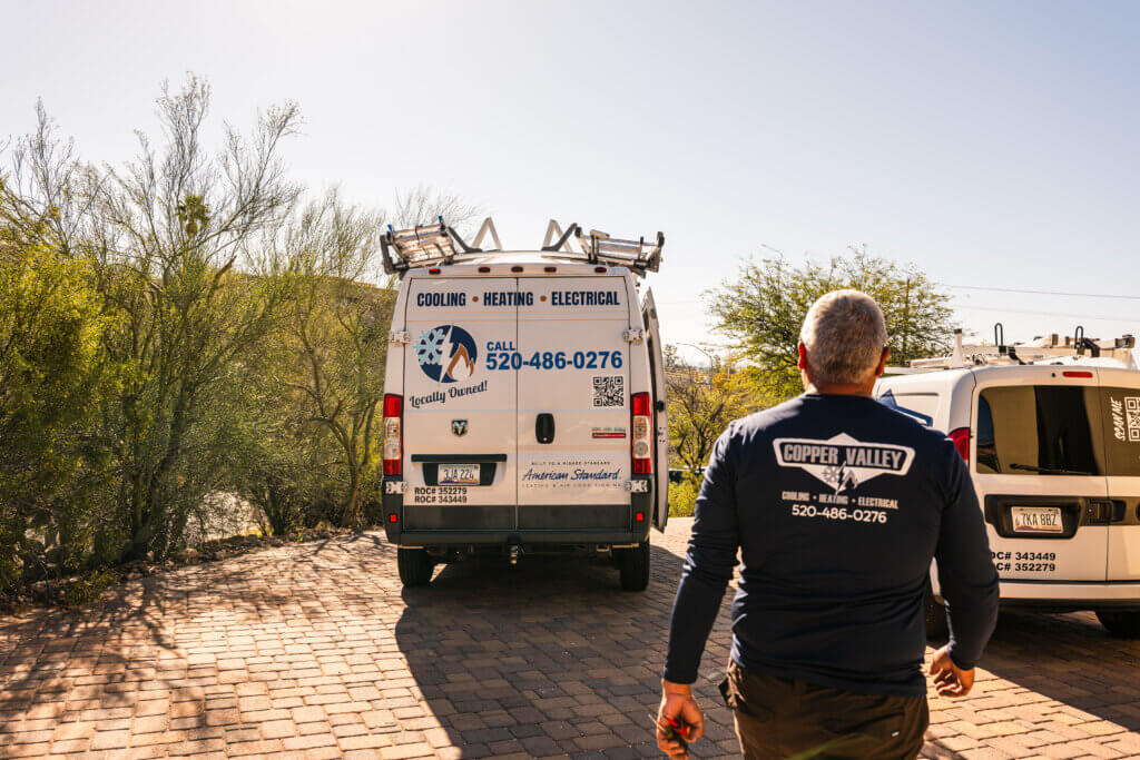Tucson A/C repair professional arriving at a service location with a fully equipped HVAC service vehicle.