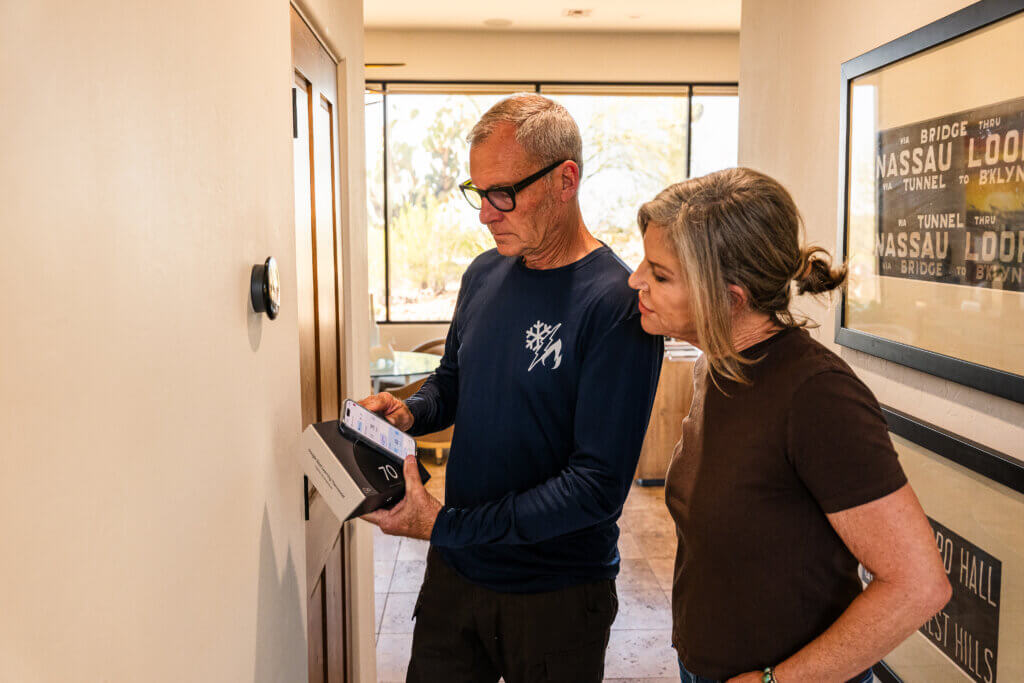 Technician explaining system diagnostics to a homeowner during a Tucson air conditioner repair service visit.